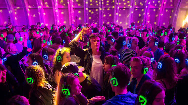 Indoor packed silent disco with glowing LED headphones